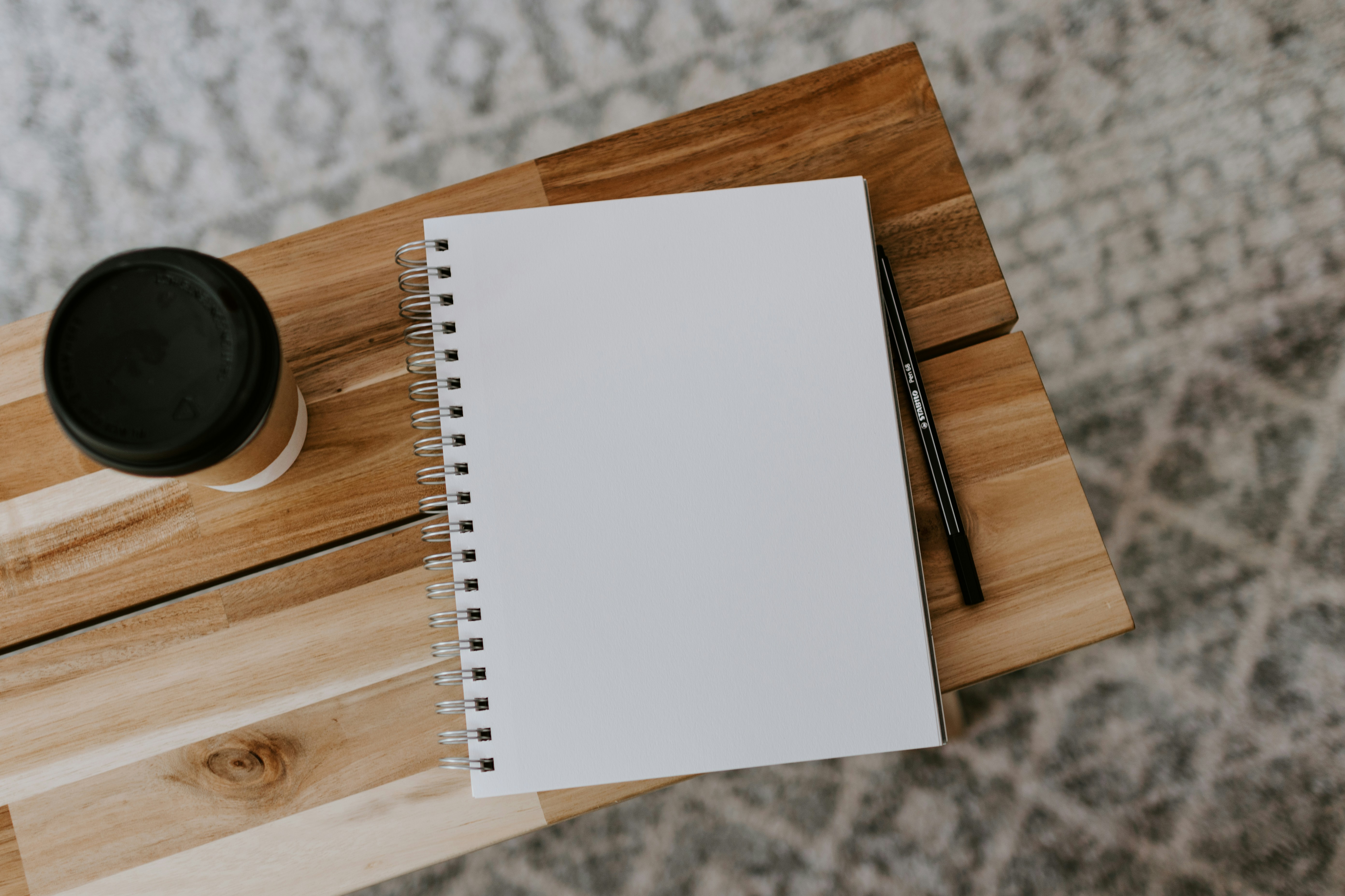 Buku catatan dan secangkir kopi di atas meja